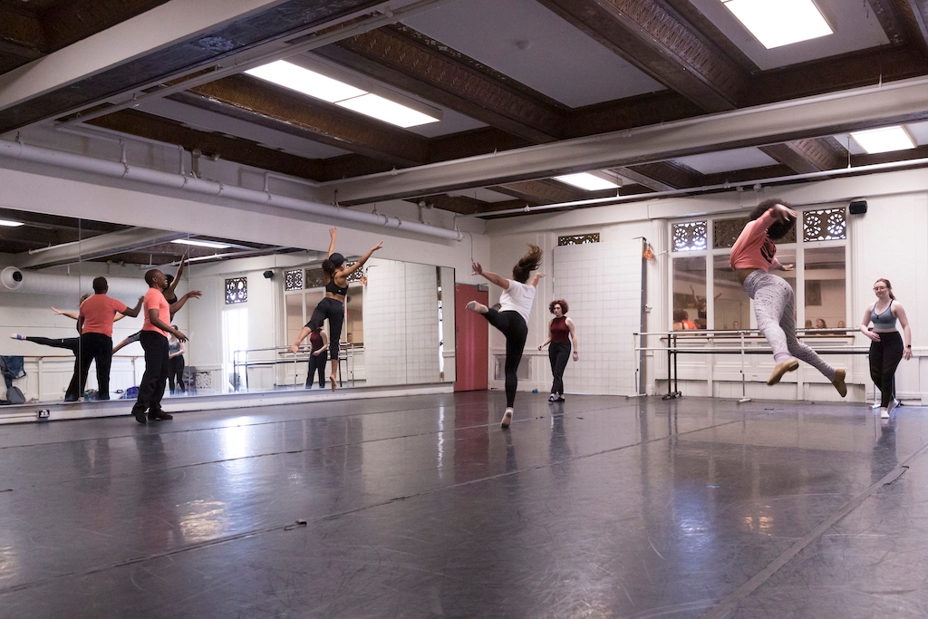Students jumping in mid-air during a music theatre studio dance class